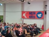 Zuschauer und Banner am der Wand. München, 13. Februar 2026. Foto: Sergej Perelman
